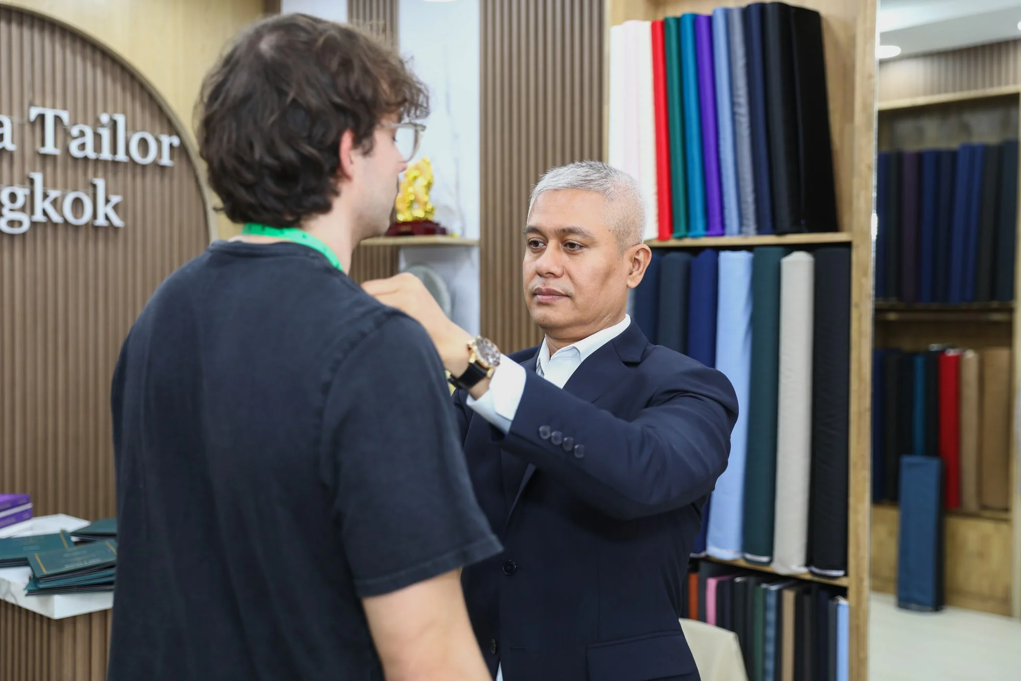 Jack measuring a client’s neck for a tailored collar