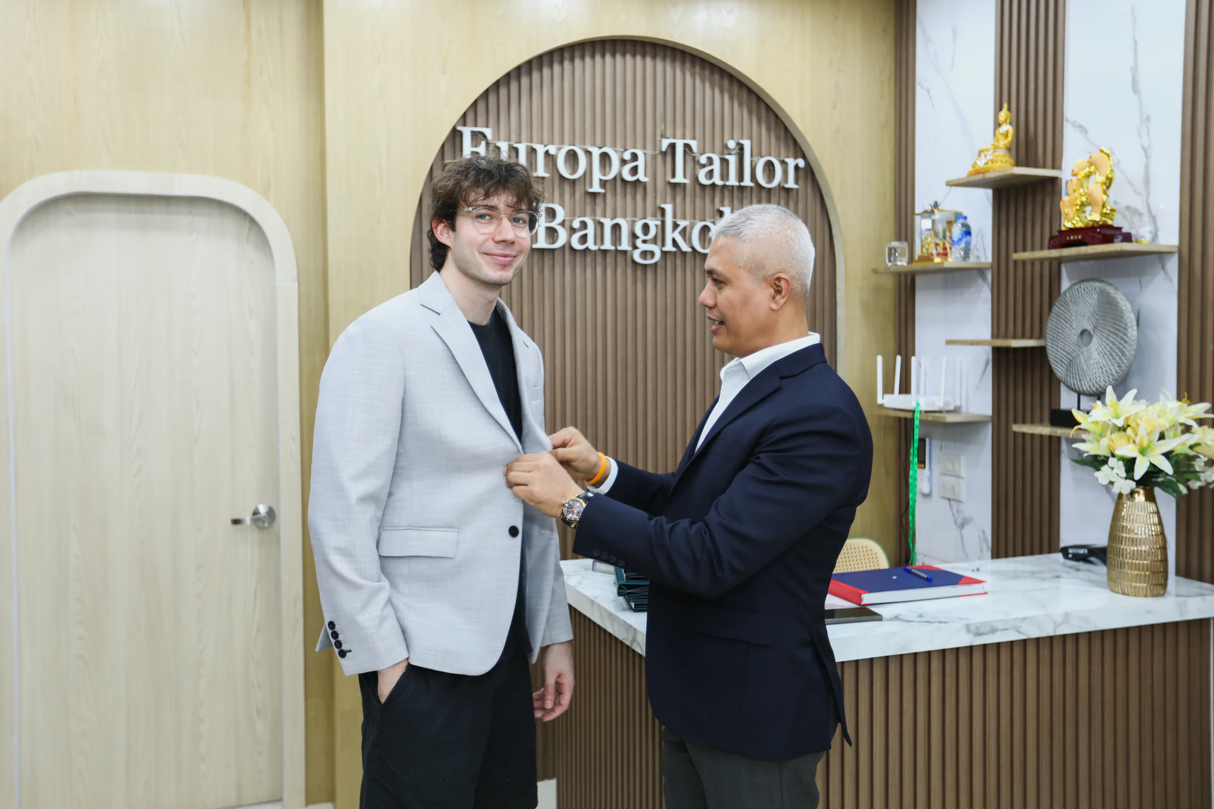 Checking a jacket on a client during a fitting