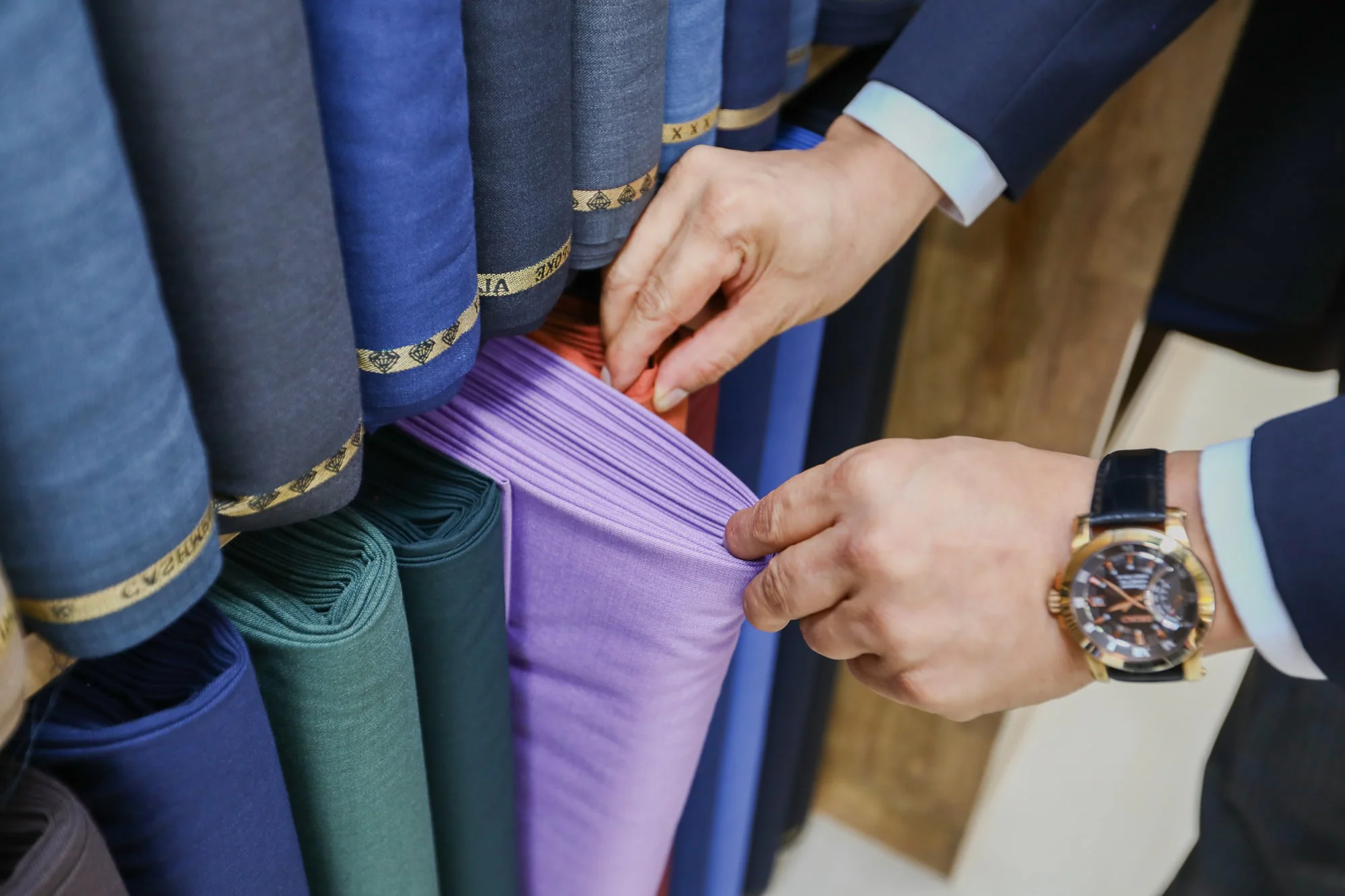 Jack feeling the drape of lavender cloth in the showroom